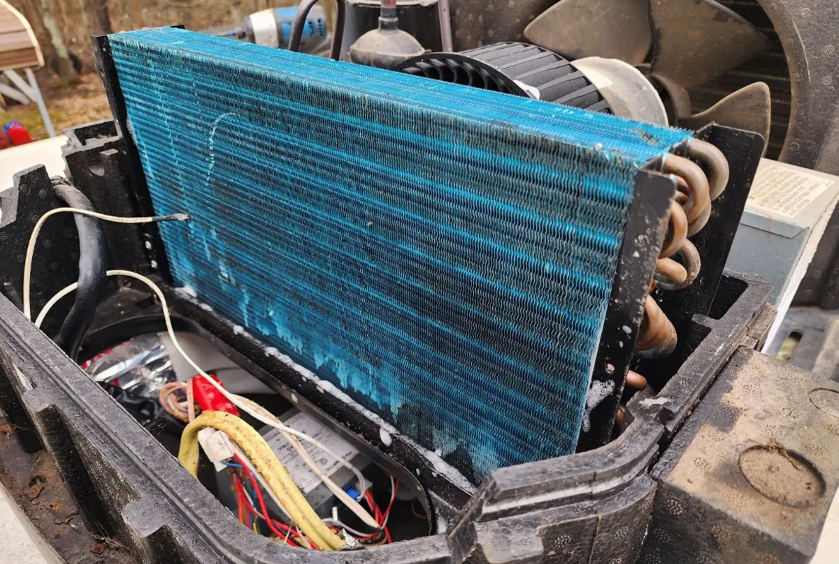 RV technician repairing a rooftop air conditioner